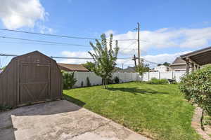 Fenced backyard with a patio area and a shed