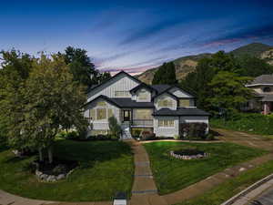 View of front of home featuring board and batten siding, a lawn, concrete driveway, an attached garage, and a mountain view