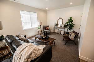 Carpeted living area with recessed lighting