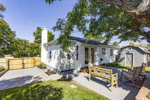 Back of house featuring french doors, a shed, a chimney, a gate, and a patio