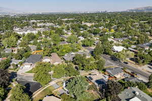 Aerial view of property and surrounding area featuring nearby suburban area and a mountain backdrop