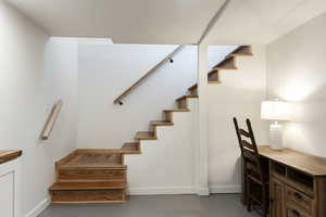 Staircase with finished concrete flooring and baseboards