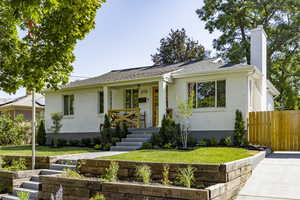 View of front of property with brick siding, a chimney, and a shingled roof