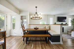 Dining room with light wood finished floors and a chandelier