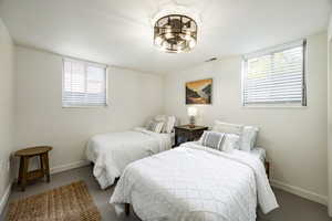 Bedroom with multiple windows and concrete floors