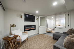 Living area with recessed lighting and a glass covered fireplace