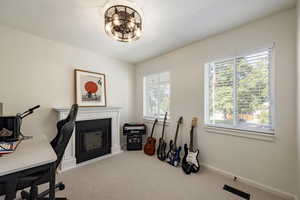 Office featuring carpet flooring and a glass covered fireplace