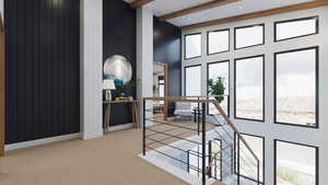 Hall with beam ceiling, a towering ceiling, carpet floors, and an upstairs landing