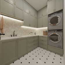 Washroom with stacked washing machine and dryer, cabinet space, and tile patterned floors