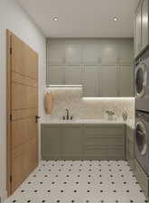 Laundry area with cabinet space, stacked washer and clothes dryer, and recessed lighting