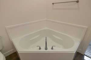 Bathroom featuring a bath and wood finished floors
