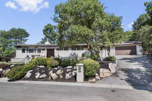 View of front of home featuring asphalt driveway, an attached garage, and a chimney
