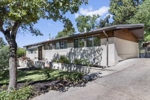 View of front facade with stucco siding and driveway