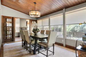 Dining room featuring wood ceiling, lofted ceiling, and light wood finished floors