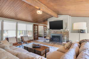 Living area featuring wood finished floors, a high end fireplace, wooden ceiling, and french doors