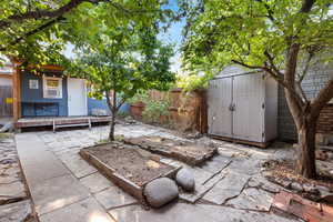 Fenced backyard featuring a shed and a patio