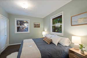 Carpeted bedroom featuring multiple windows