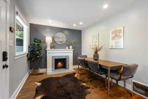 Dining space featuring wood finished floors, recessed lighting, and a fireplace