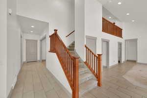 Stairs to loft beautiful railing and a towering ceiling.