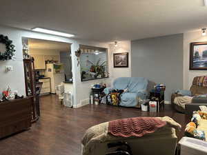 Living room with dark wood finished floors and a textured ceiling