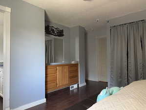 Bedroom with dark wood-type flooring and a textured ceiling
