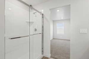 Bathroom with a shower stall and recessed lighting