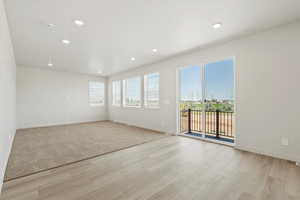 Spare room featuring healthy amount of natural light, recessed lighting, and light wood-style floors