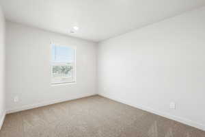 Spare room featuring light carpet and baseboards