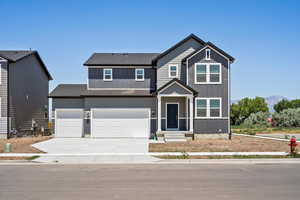 View of front facade with board and batten siding, concrete driveway, a shingled roof, and an attached garage