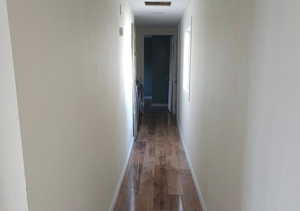Hall with hardwood / wood-style flooring and baseboards