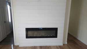 Detailed view of a glass covered fireplace and wood finished floors