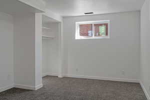 Unfurnished bedroom featuring dark colored carpet and a closet