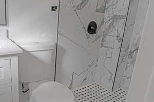 Bathroom with a marble finish shower and vanity