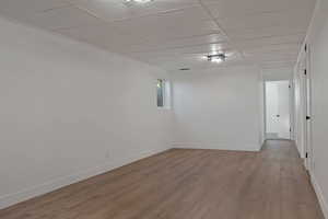Spare room featuring a paneled ceiling and wood finished floors