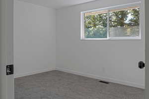 Empty room with carpet floors and baseboards