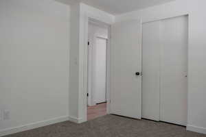 Unfurnished bedroom featuring carpet and a closet