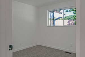 Empty room with carpet floors and baseboards