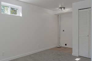 Basement featuring light colored carpet and baseboards
