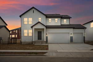 Modern farmhouse style home featuring board and batten siding, concrete driveway, an attached garage, and roof with shingles