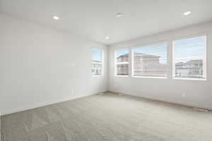 Carpeted empty room with recessed lighting