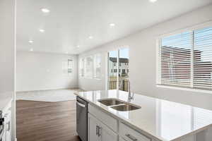 Kitchen with white cabinetry, light stone countertops, recessed lighting, an island with sink, and dishwasher