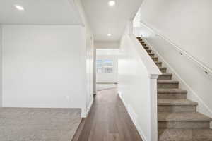 Stairs with recessed lighting and wood finished floors