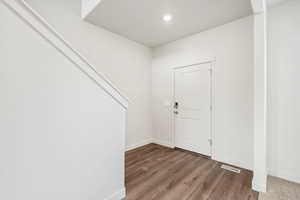 Foyer entrance with dark wood finished floors and recessed lighting