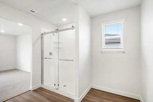 Full bath featuring a stall shower and dark wood-type flooring