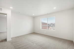Spare room featuring light colored carpet and recessed lighting