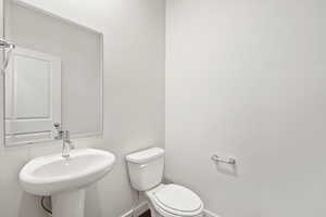 Half bath featuring toilet and baseboards
