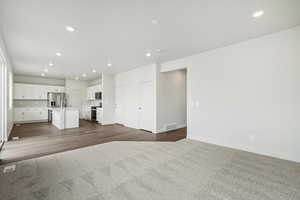 Unfurnished living room with recessed lighting and dark carpet