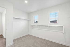 Walk in closet featuring light carpet