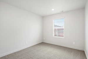 Carpeted spare room featuring baseboards and recessed lighting