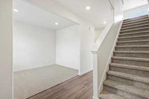 Stairway featuring recessed lighting and wood finished floors